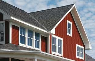 Red home with a dark gray shingle roof